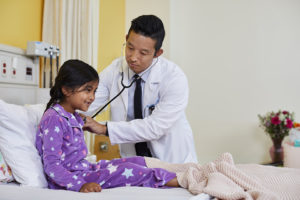 pediatrician and patient in purple pajamas