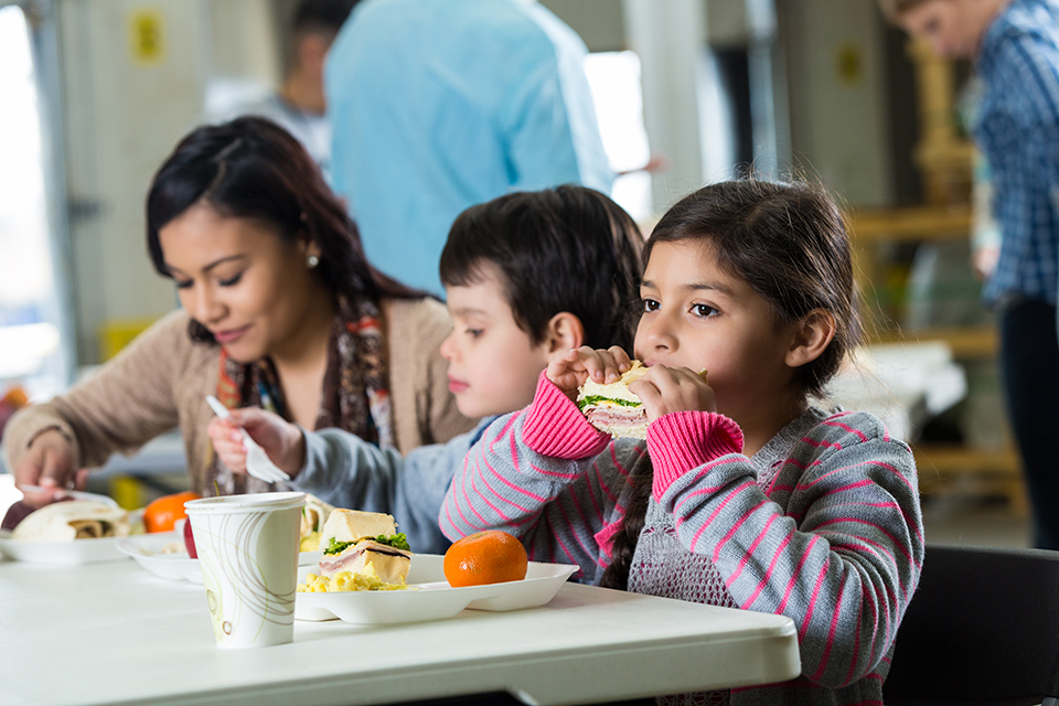 Young Hispanic family eating healthy meal in food bank