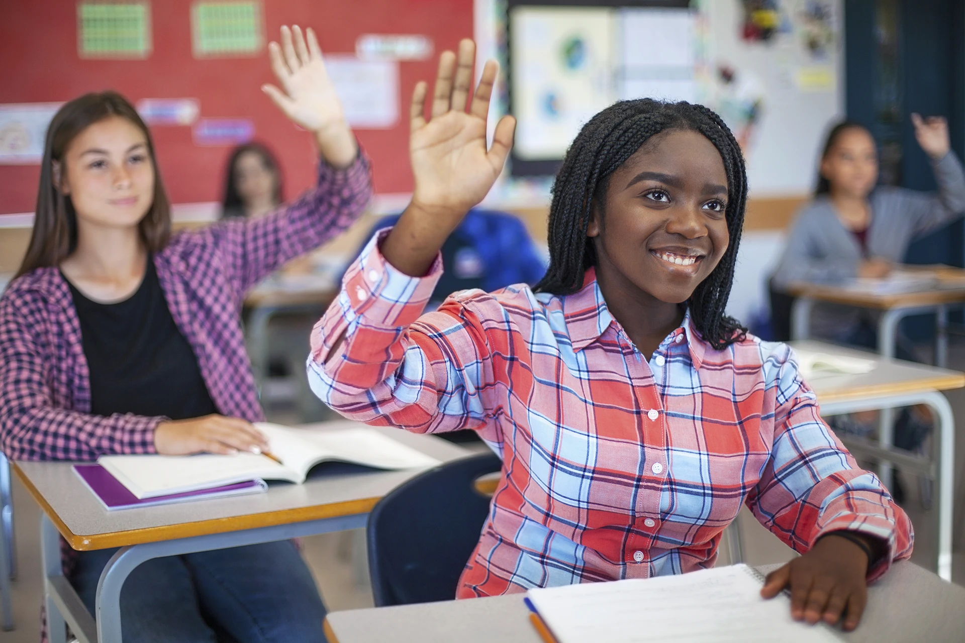 High school student raising hand in classroom