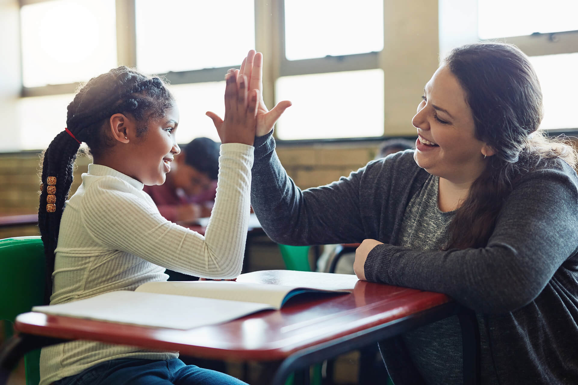 Student and teacher giving each other a high five
